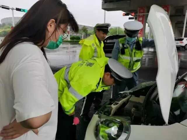 车辆雨中抛锚，民**合力推车